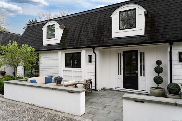 exterior space featuring a patio, board and batten siding, and roof with shingles