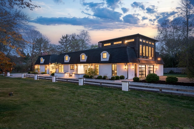 back of house at dusk with a yard