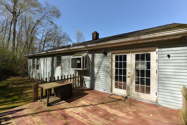back of house featuring french doors, a chimney, and a deck
