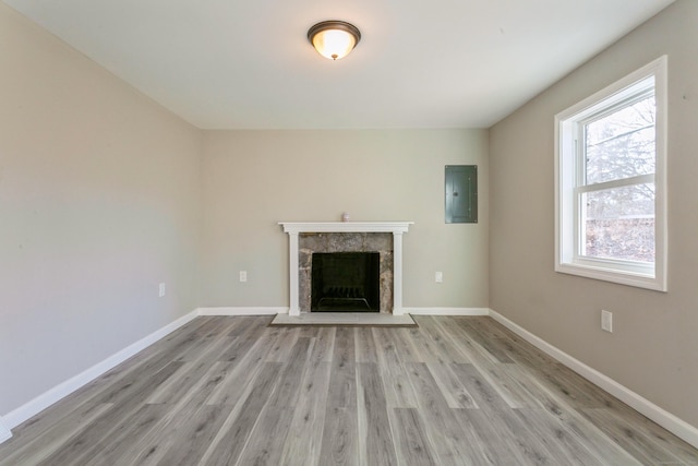 16 Old Hawleyville Rd, Newtown, CT 06470 - unfurnished living room featuring baseboards, light wood-type flooring, electric panel, and a fireplace