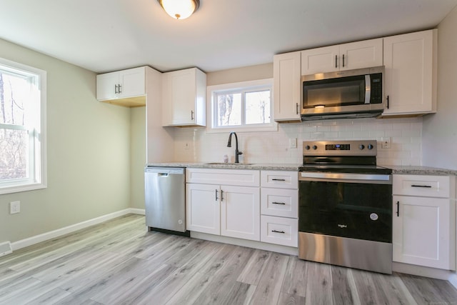 16 Old Hawleyville Rd, Newtown, CT 06470 - kitchen featuring a sink, stainless steel appliances, backsplash, light wood-style flooring, and white cabinets