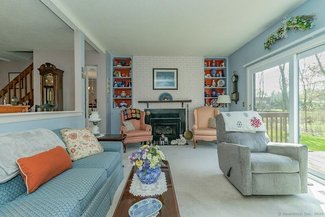 living room with built in shelves, stairs, carpet, and a fireplace