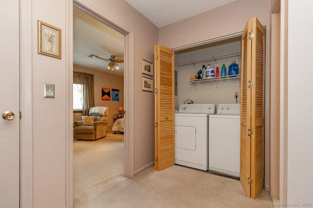 clothes washing area with light carpet, laundry area, and washer and clothes dryer