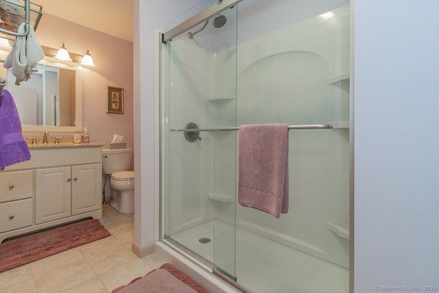 full bathroom with vanity, toilet, tile patterned flooring, and a stall shower