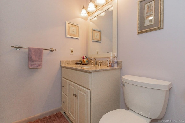 half bathroom featuring toilet and vanity