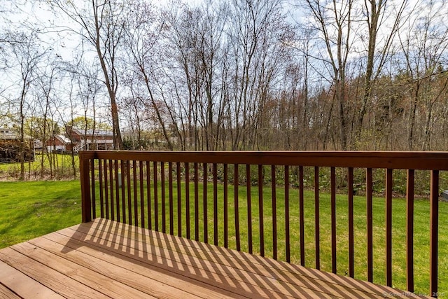 wooden deck featuring a lawn