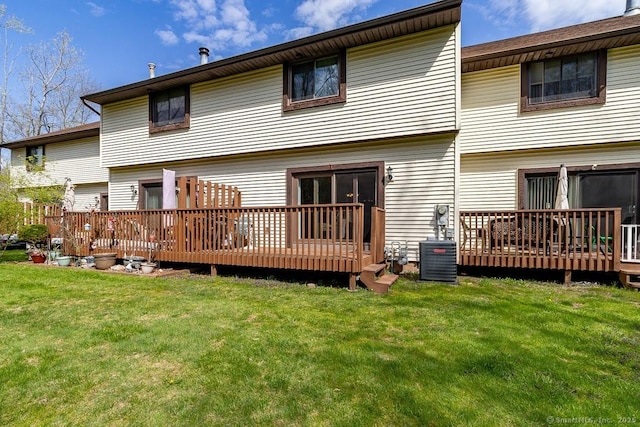 back of house featuring a wooden deck, cooling unit, and a lawn