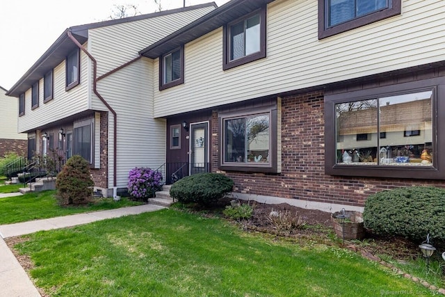 multi unit property featuring brick siding and a front yard