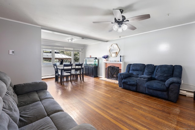 living room featuring wood finished floors, a ceiling fan, crown molding, and a baseboard heating unit