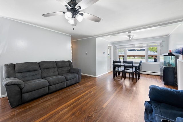 living area with ornamental molding, wood finished floors, baseboards, ceiling fan, and a baseboard heating unit