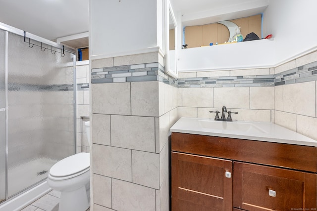 full bathroom with vanity, toilet, tile walls, and a stall shower