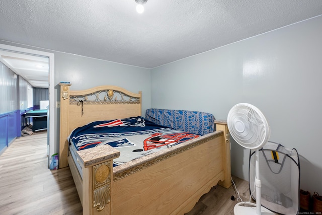 bedroom with light wood finished floors and a textured ceiling