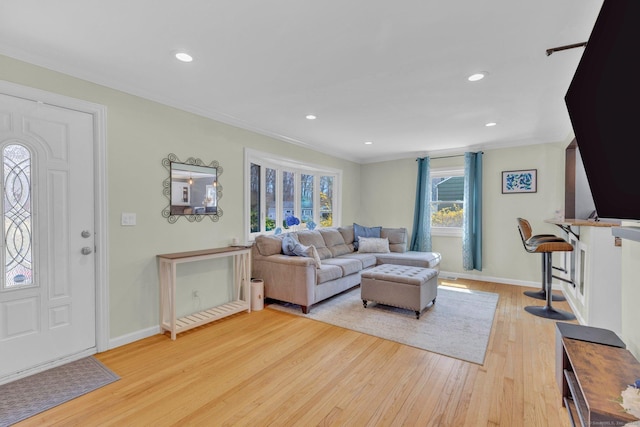 living area featuring crown molding, light wood-style flooring, recessed lighting, and baseboards