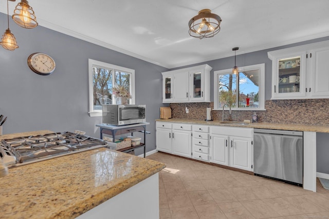 kitchen with white cabinets, appliances with stainless steel finishes, decorative backsplash, and a sink