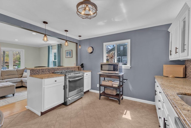 kitchen featuring white cabinetry, crown molding, appliances with stainless steel finishes, open floor plan, and decorative light fixtures