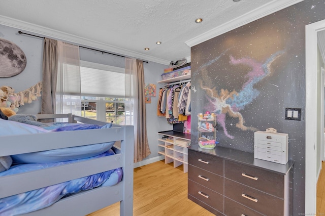 bedroom with a textured ceiling, light wood-style floors, baseboards, recessed lighting, and ornamental molding