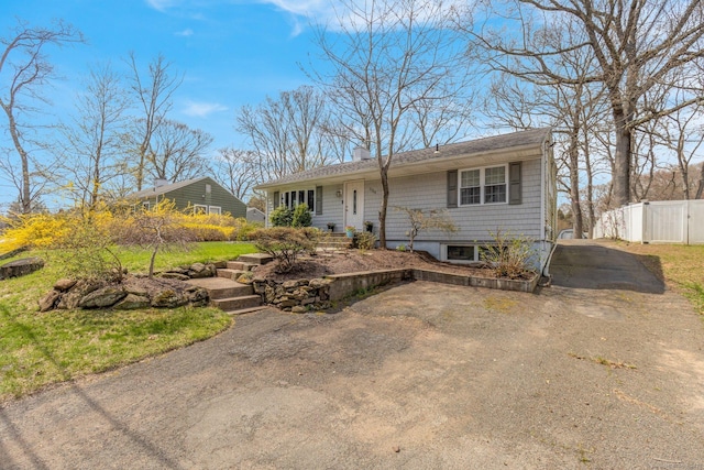 single story home featuring a chimney and fence