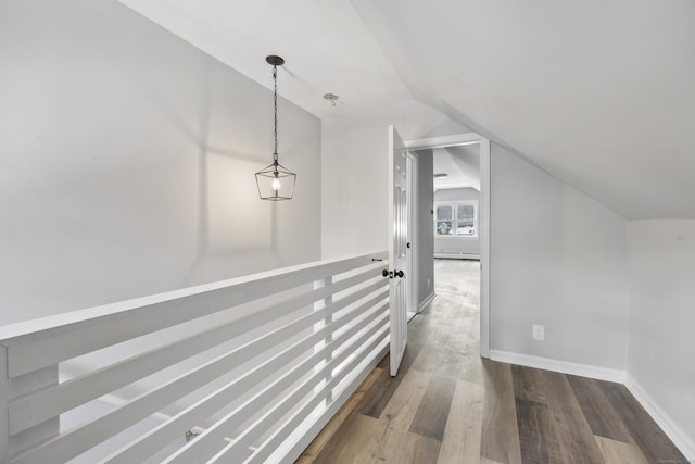 hallway featuring baseboards, lofted ceiling, and dark wood-type flooring