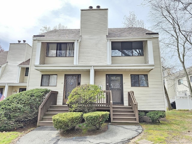 multi unit property featuring covered porch and a chimney