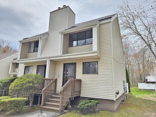 multi unit property with a front lawn and a chimney