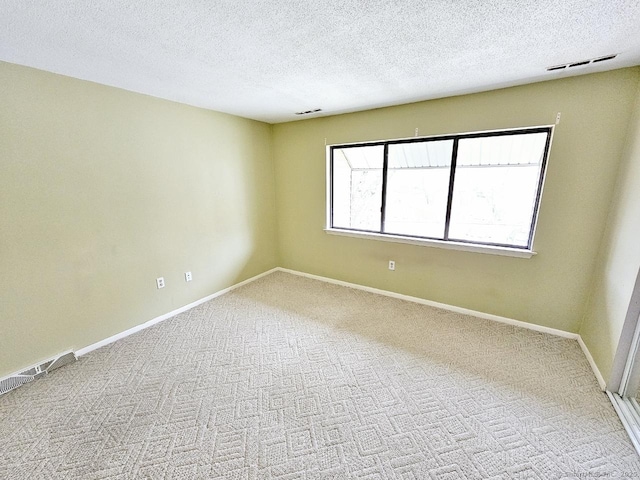 unfurnished room featuring baseboards, a textured ceiling, and carpet flooring