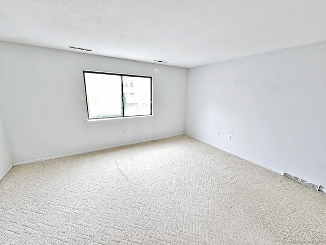 spare room with baseboards and carpet floors