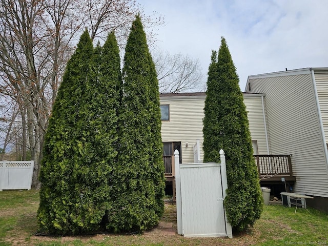 view of side of property featuring a wooden deck and fence