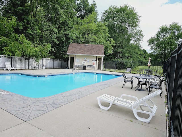 pool with a patio and fence