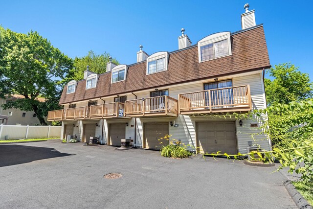 268 Lawlor St Apt 6, New Britain, CT 06051 - rear view of house featuring a shingled roof, a garage, and a chimney