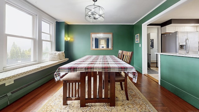 dining space with a baseboard radiator, ornamental molding, dark wood-style floors, and baseboards
