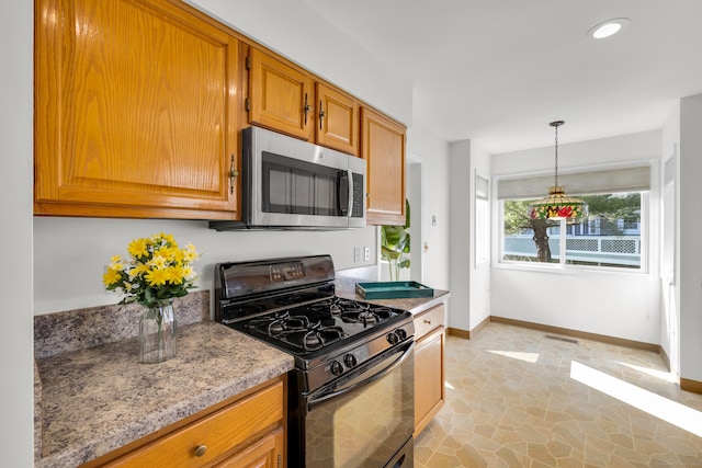 kitchen with stainless steel microwave, visible vents, baseboards, gas stove, and brown cabinetry