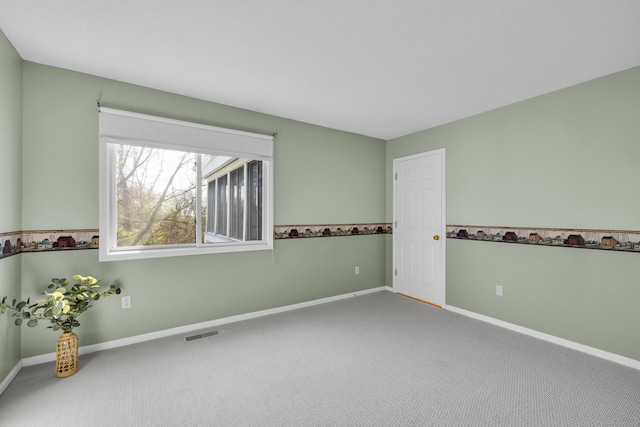 carpeted empty room featuring baseboards and visible vents