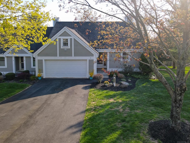 view of front of home with a garage, a shingled roof, driveway, and a front yard