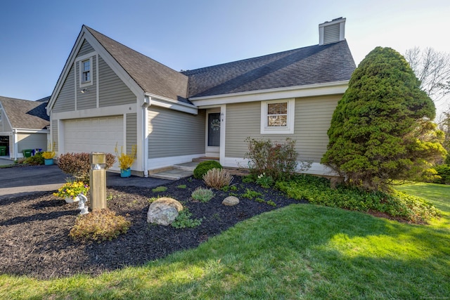view of front of home featuring a chimney, aphalt driveway, a shingled roof, a garage, and a front yard