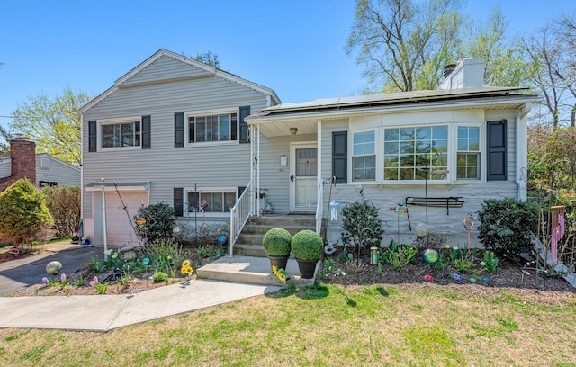 9 Berkshire Dr, Danbury, CT 06811 - tri-level home with an attached garage, a front lawn, aphalt driveway, a chimney, and solar panels