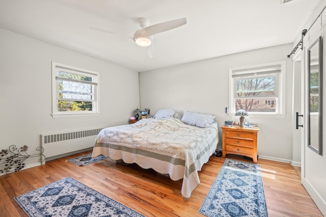 9 Berkshire Dr, Danbury, CT 06811 - bedroom featuring a ceiling fan, a barn door, wood finished floors, baseboards, and radiator heating unit