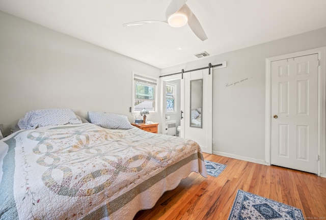 9 Berkshire Dr, Danbury, CT 06811 - bedroom with ceiling fan, a barn door, baseboards, wood finished floors, and visible vents