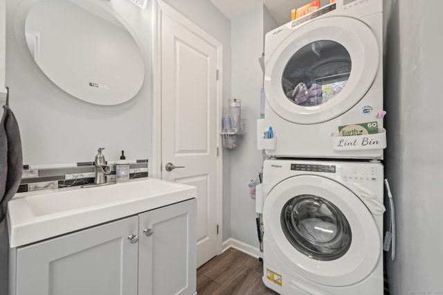 9 Berkshire Dr, Danbury, CT 06811 - clothes washing area with stacked washer and dryer, baseboards, dark wood finished floors, a sink, and cabinet space