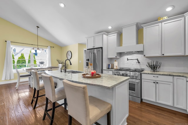 kitchen with high quality appliances, a sink, lofted ceiling, tasteful backsplash, and custom exhaust hood