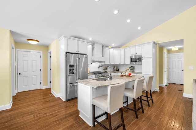 kitchen featuring dark wood-style flooring, light stone countertops, premium range hood, stainless steel appliances, and recessed lighting