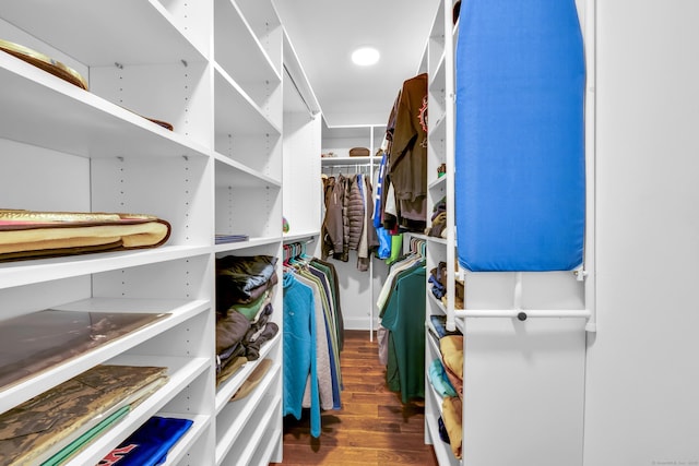 walk in closet with wood finished floors