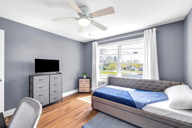 bedroom with baseboards, ceiling fan, and wood finished floors