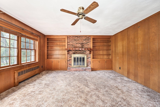 30 Sunset Hill Rd, Simsbury, CT 06070 - unfurnished living room featuring radiator, built in features, wood walls, carpet flooring, and a ceiling fan