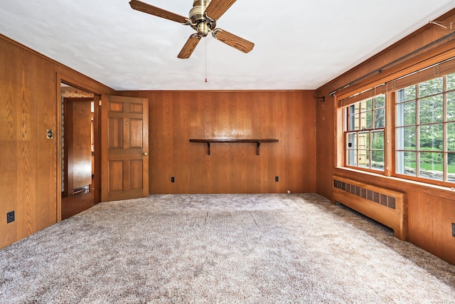 30 Sunset Hill Rd, Simsbury, CT 06070 - spare room featuring radiator heating unit, wood walls, carpet floors, and ceiling fan