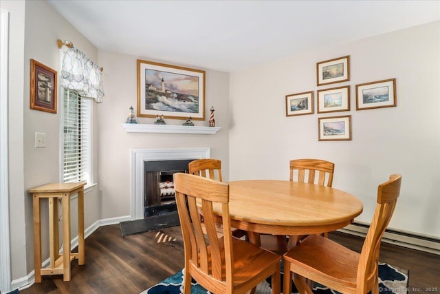 20 E Pembroke Rd Unit 36, Danbury, CT 06811 - dining space with a baseboard heating unit, baseboards, dark wood finished floors, and a fireplace with flush hearth