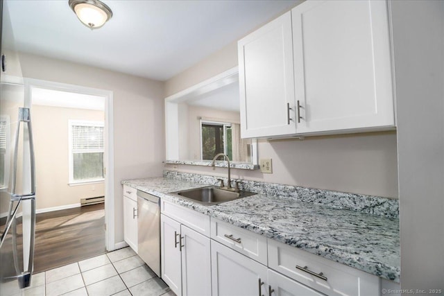 20 E Pembroke Rd Unit 36, Danbury, CT 06811 - kitchen with white cabinets, a sink, stainless steel appliances, light tile patterned floors, and a baseboard radiator