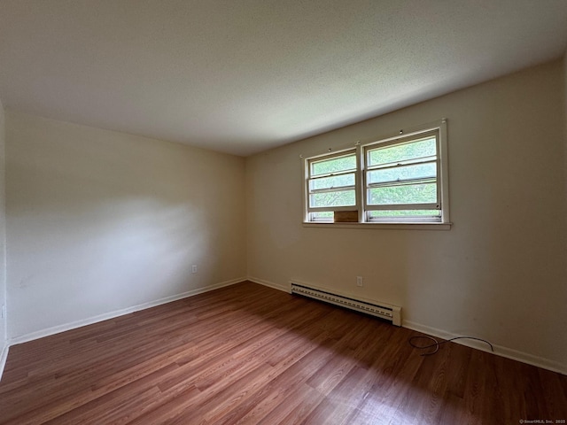 136 Westbury Park Rd Apt C, Watertown, CT 06795 - spare room featuring a baseboard radiator, wood finished floors, and baseboards