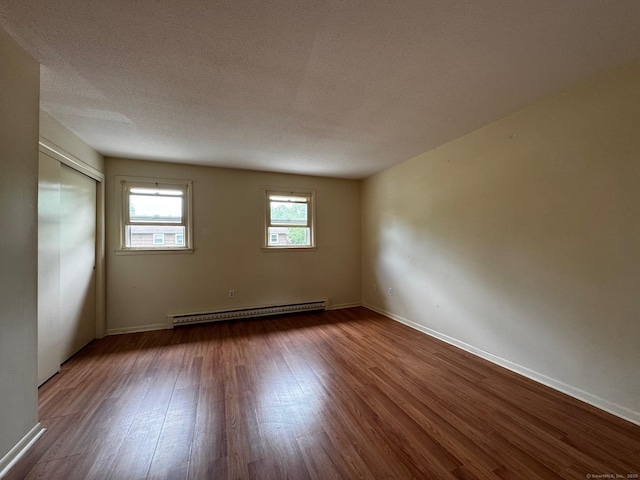 136 Westbury Park Rd Apt C, Watertown, CT 06795 - unfurnished room with a baseboard radiator, dark wood-style floors, baseboards, and a textured ceiling