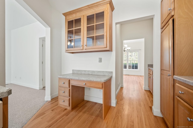 corridor with baseboards, light wood-type flooring, and an inviting chandelier
