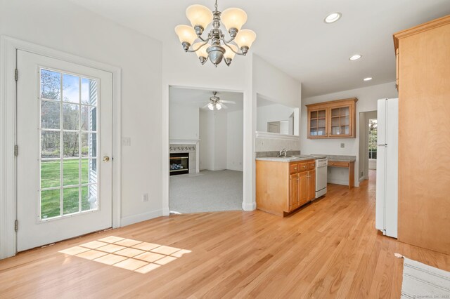 kitchen featuring plenty of natural light, a sink, light countertops, and white appliances